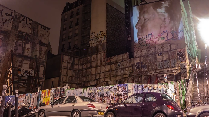 Performance de projection sauvage mêlant art urbain et vidéo mapping dans les rues de Paris.