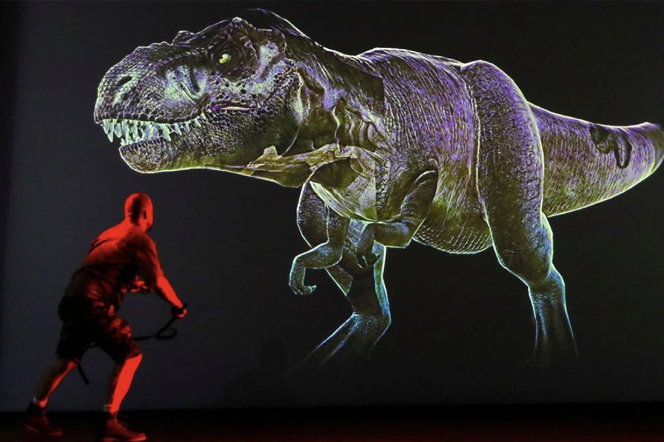 Projection d’un tyrannosaure lumineux face à un humain dans un espace sombre – Prehistoric Safari, art préhistorique urbain
