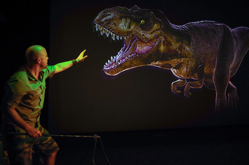 Homme faisant face à un tyrannosaure projeté en taille réelle – Prehistoric Safari, rencontre homme et préhistoire