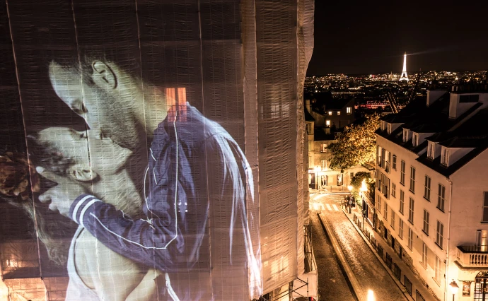 Projection monumentale d’un couple s’embrassant sur une façade parisienne de nuit – Le Baiser, video-mapping de Julien Nonnon