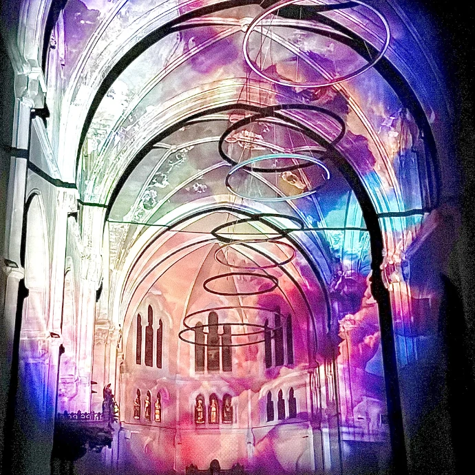 Projection monumentale de couleurs et de spirales lumineuses dans la nef de l’église Notre-Dame de Saint-Chamond – art numérique