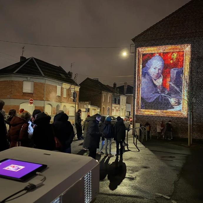Safari Urbain Arras – Un portrait qui chante dans la rue Portrait ancien projeté sur une façade à Arras, semblant chanter lors d’une déambulation nocturne de Safari Urbain pendant les fêtes