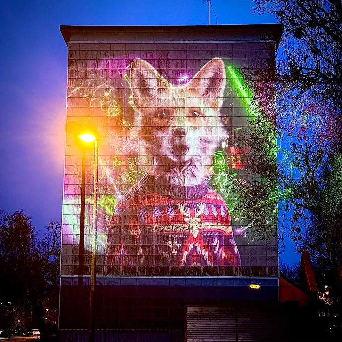 Safari Urbain Arras – Une œuvre chantante et festive Animal anthropomorphe projeté sur un immeuble à Arras, chantant sur des airs festifs lors de Safari Urbain
