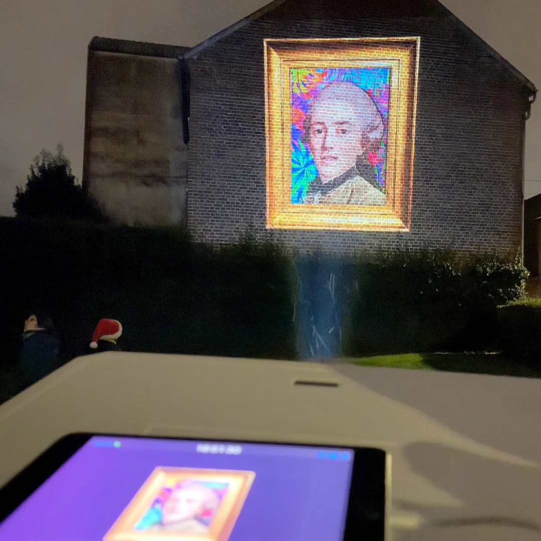 Safari Urbain Arras – Le patrimoine mis en voix pour les fêtes Portrait du XVIIIe siècle projeté et animé, chantant sur une façade arrageoise pendant les fêtes de fin d’année – Safari Urbain