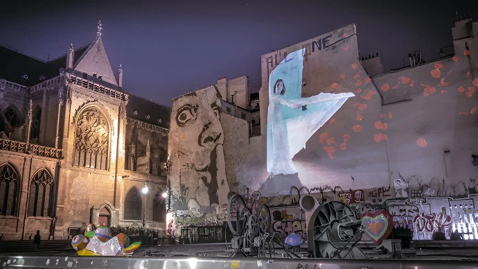 Danse de Fleurs – La danse projetée dans les rues de Paris Projection artistique d’une danseuse aux voiles sur une façade parisienne, création Danse de Fleurs inspirée de Loïe Fuller