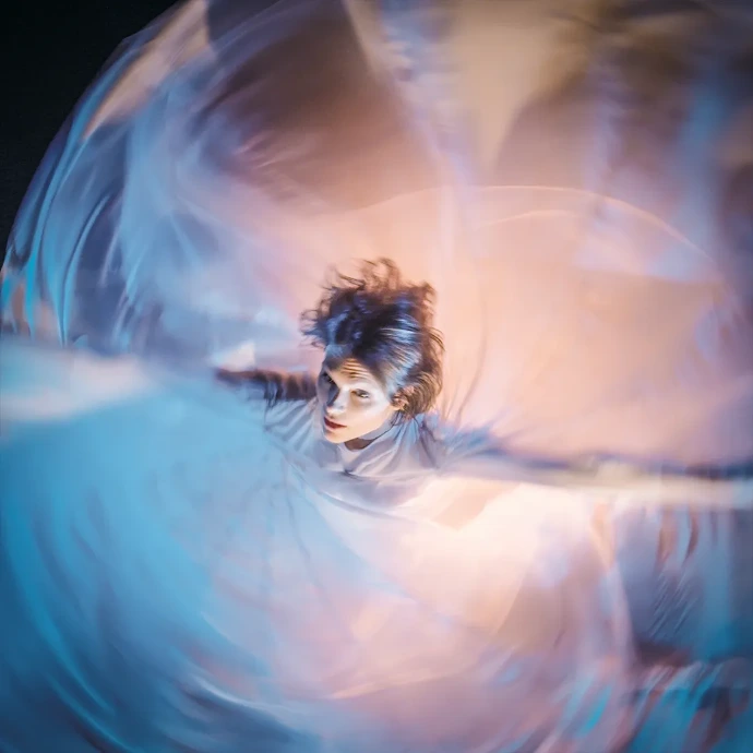 Danse de Fleurs – La danse comme souffle vivant Danseuse en mouvement circulaire avec voiles, création Danse de Fleurs alliant danse contemporaine, lumière et poésie